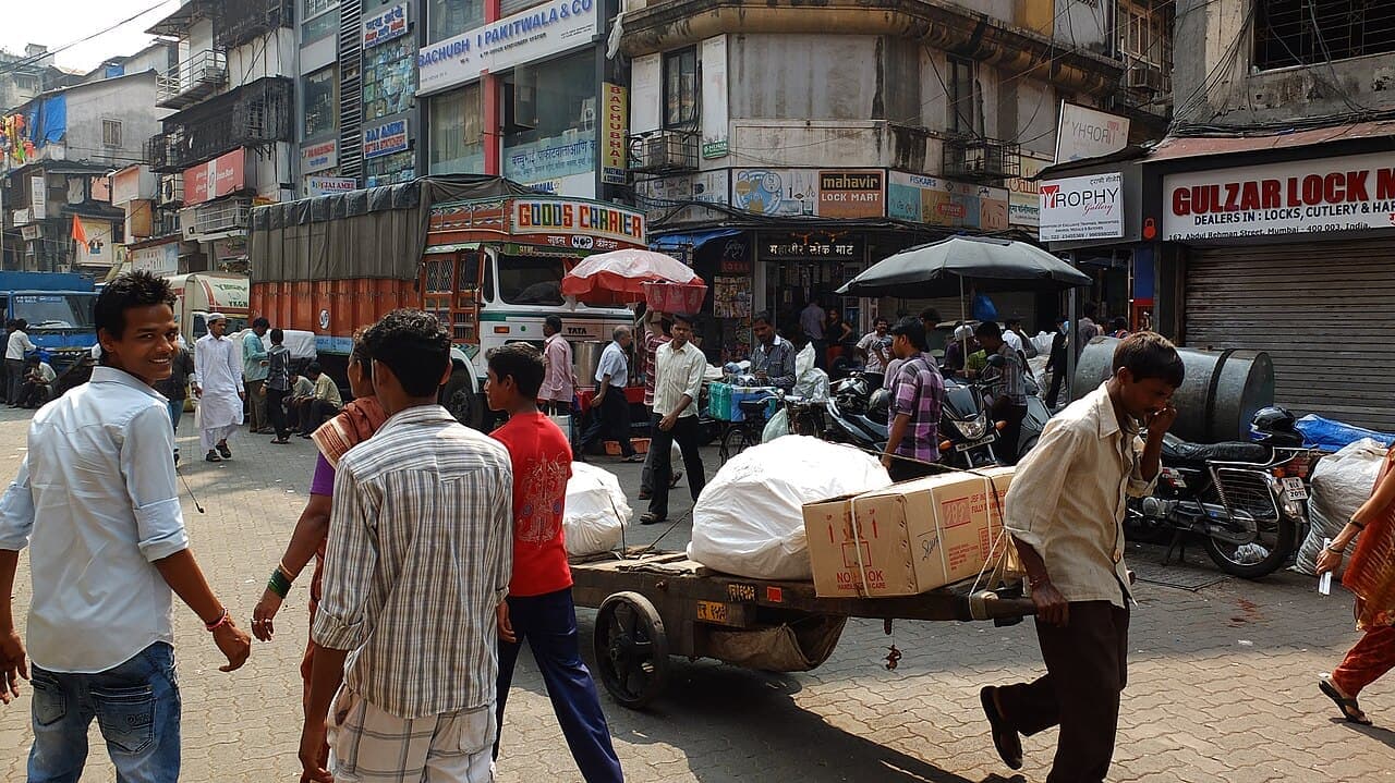 A porter pulling a loaded handcart through Crawford Market, Mumbai