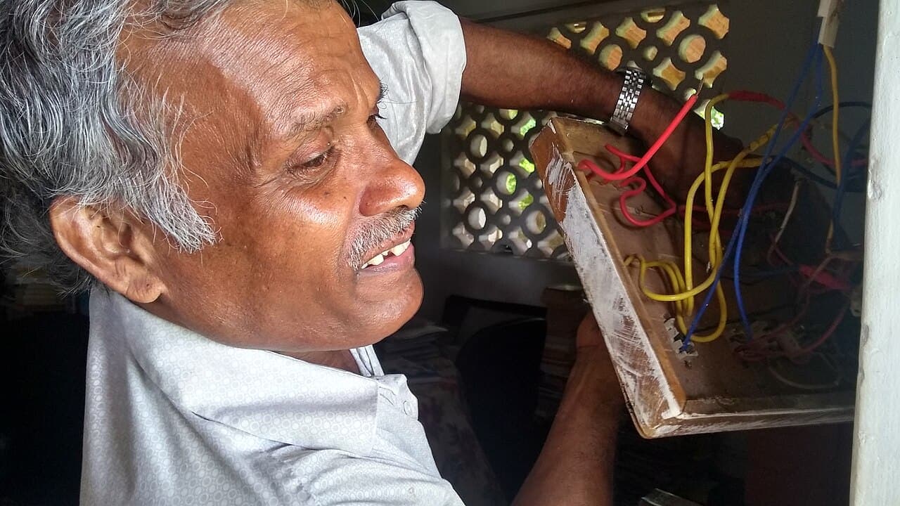 An electrician wiring a switchboard in Goa