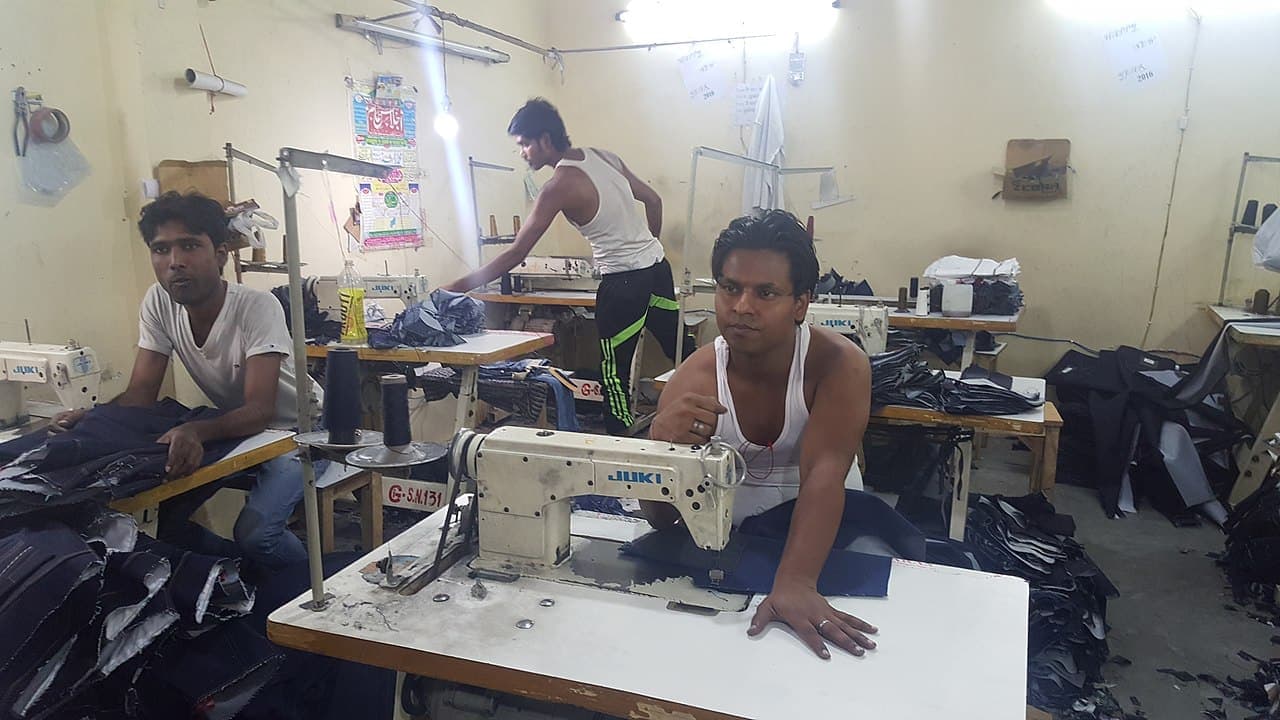 Tailors at sewing machines in a Delhi workshop